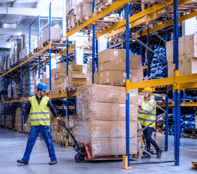 Caristes manipulant des palettes dans un entrepôt logistique